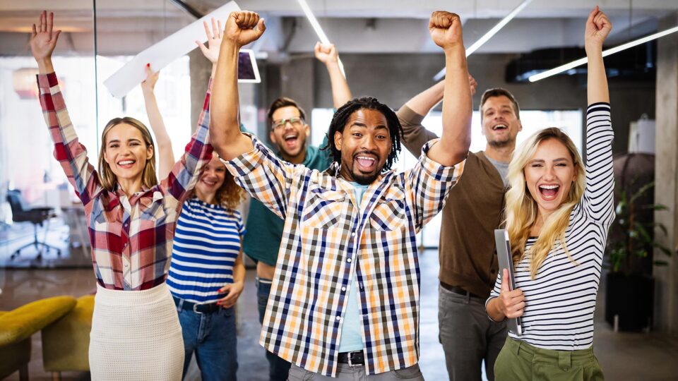 Happy business people celebrating success at company